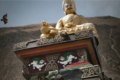4月17日一只飞鸟飞过玉树禅古寺旁倾斜的神像上空