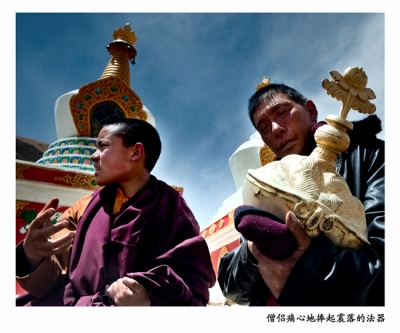 僧侣痛心地捧起震落的法器