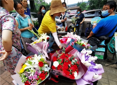 济南考点外鲜花供不应求 家长手持鲜花等待迎接考生