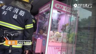 重庆：“熊孩子”钻进娃娃机 消防叔叔来救援
