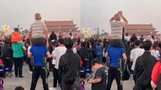 北京天安门 老父亲坐在儿子肩膀上看升旗：激动得不停鼓掌！